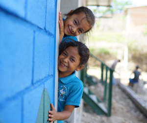 OneChild Honduran children peeking around a wall