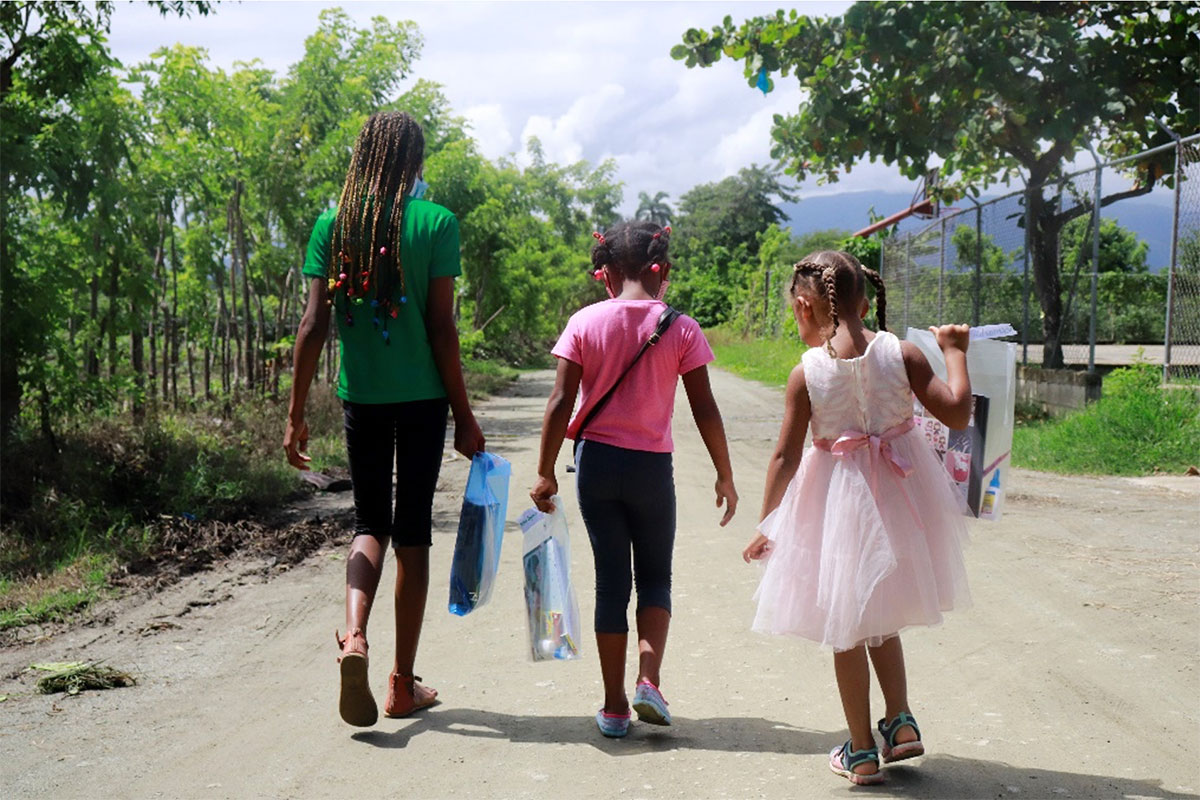 Children walk home with a bag of school supplies from their Hope Center in the Dominican Republic.