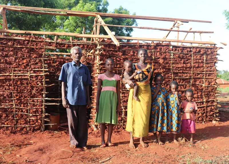 Jane, her parents and several of her siblings stand in front of their new home