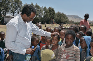 Getachew Teku greeting a crowd of children at a Hope Center